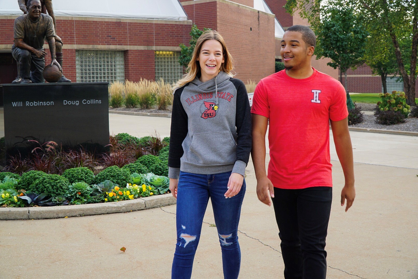 Two students walking on campus and wearing vintage Redbird apparel.