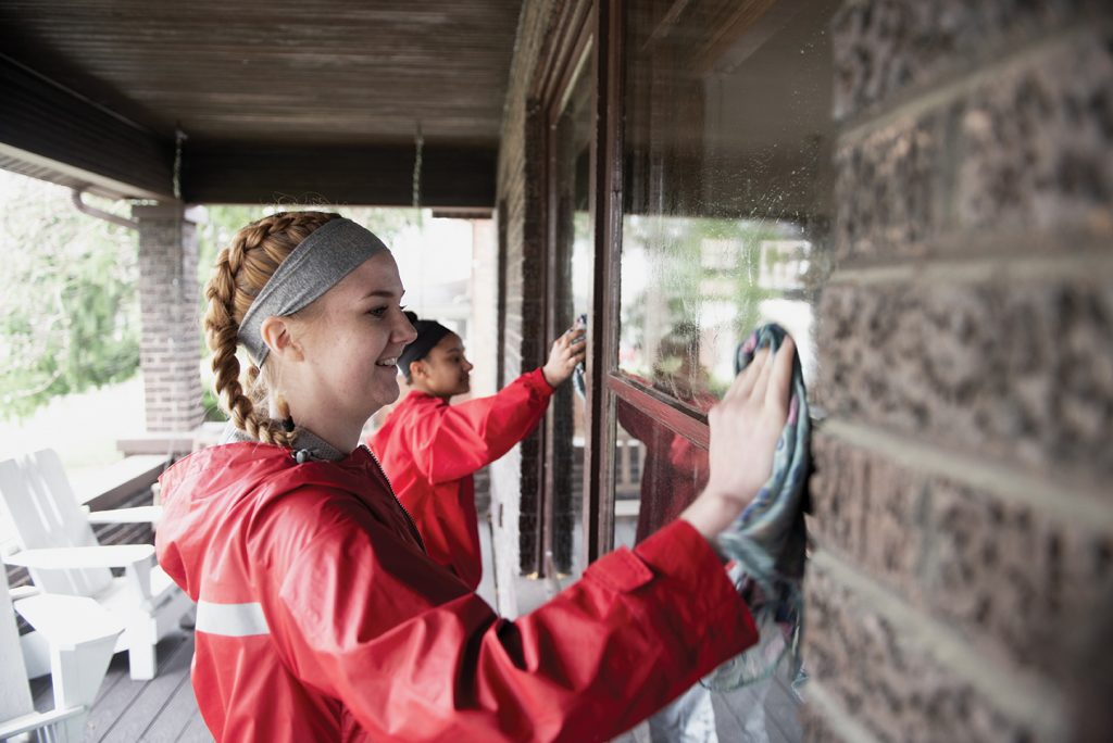 Illinois State students wash windows at a Normal home last April as part of Bring It Back to Normal.