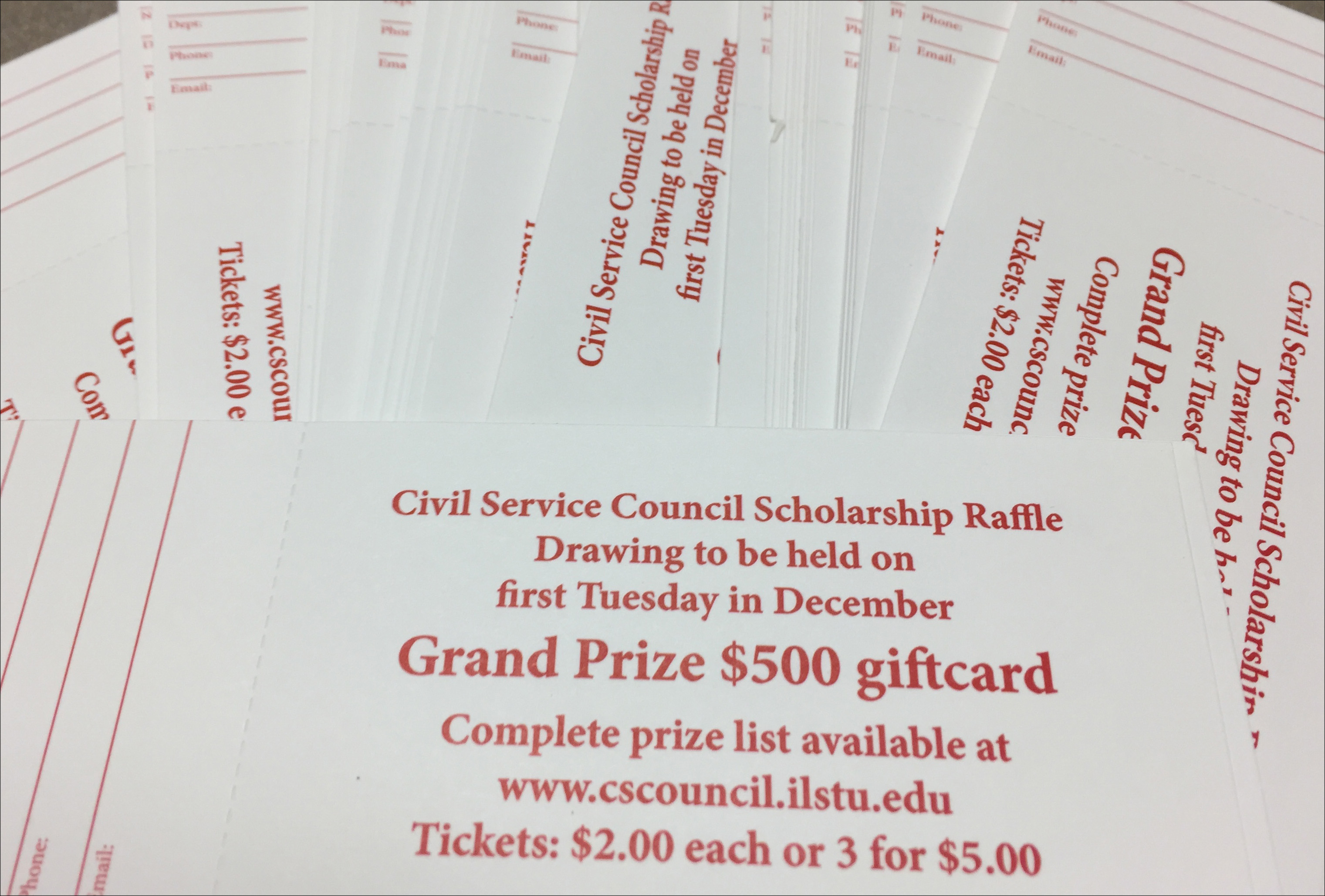 stack of raffle tickets with the words Civil Service Council Scholarship Raffle, drawing to be held on first Tuesday in December, Grand Prize $500 gift card, Complete prize list available at www.cscouncil.ilstu.edu, tickets $2 each or 3 for $5.