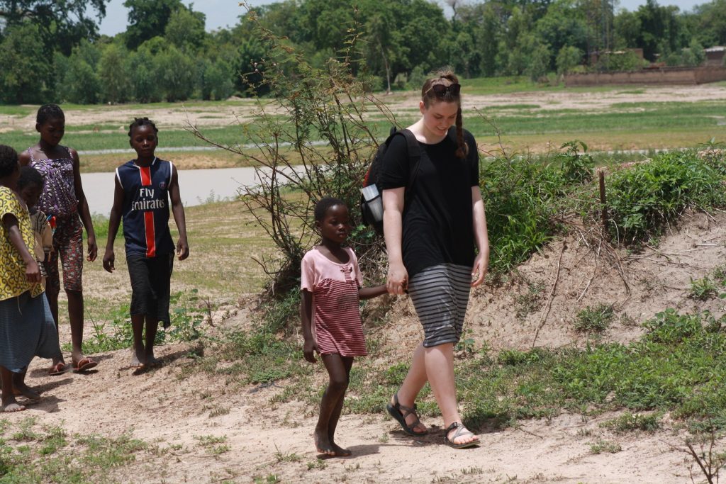 Abby Mustread, ISU Bone Scholar, walks with group of children in Africa.