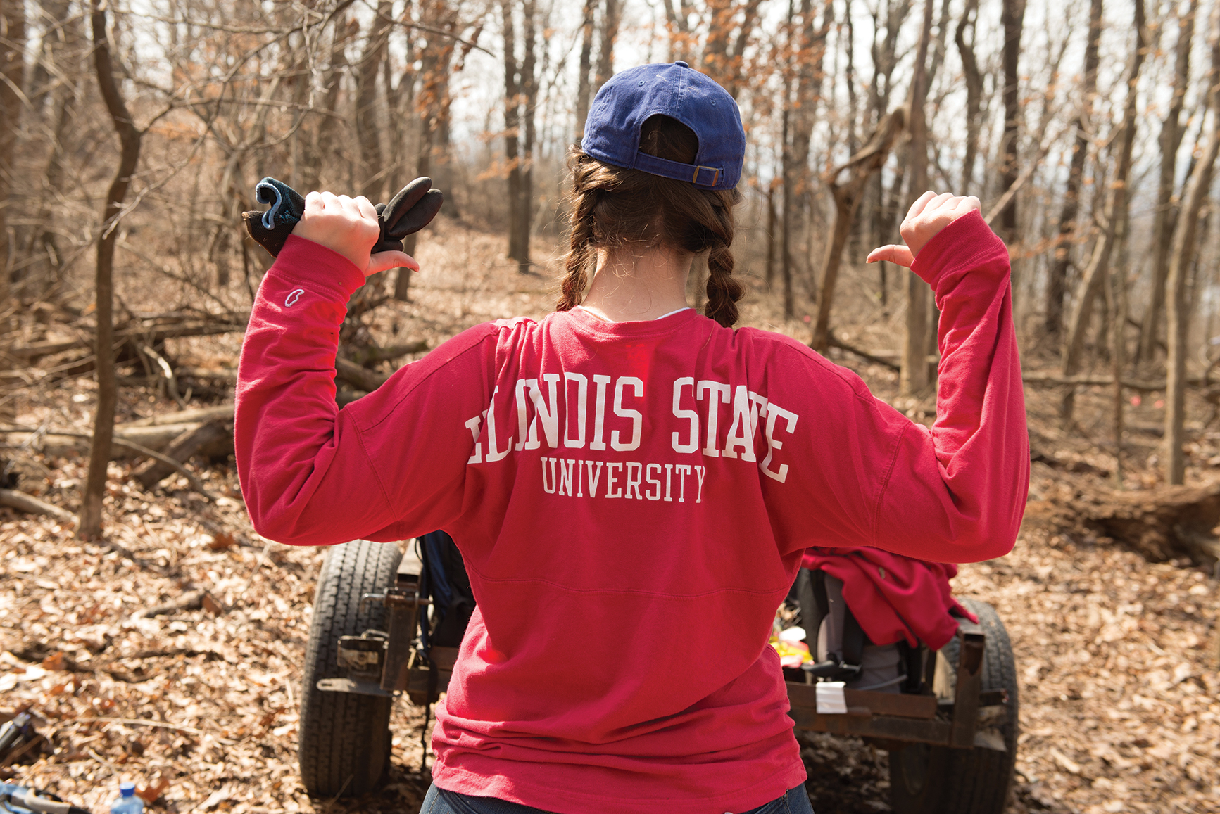 Thirty Illinois State students helped clean up the Mississippi River last spring break. Female student with back turned and Illinois State University on her shirt.