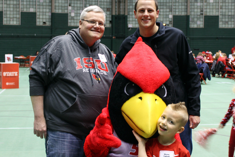 Two adults, a child and Reggie Redbird