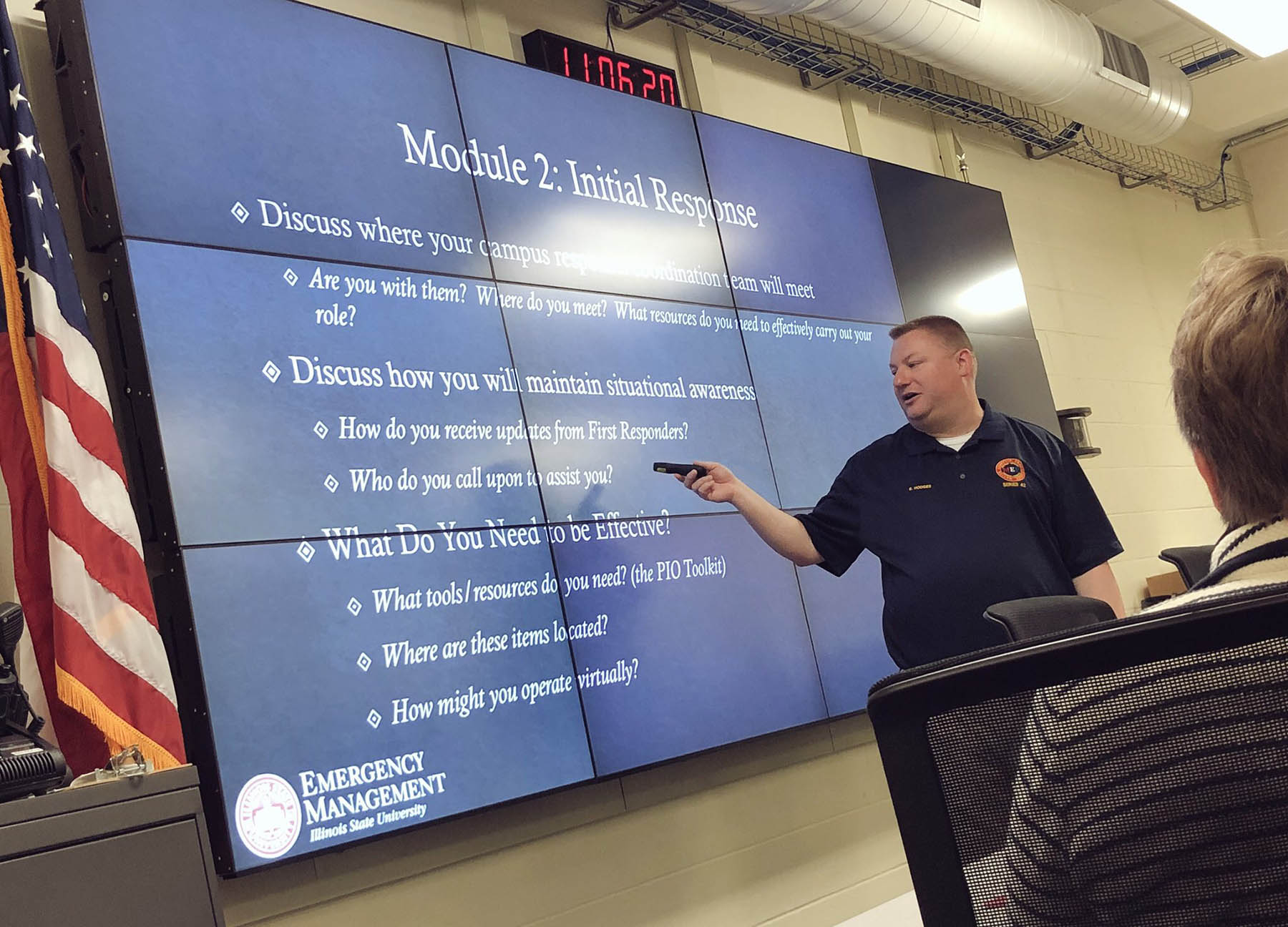 Man pointing to screens with a projected PowerPoint.