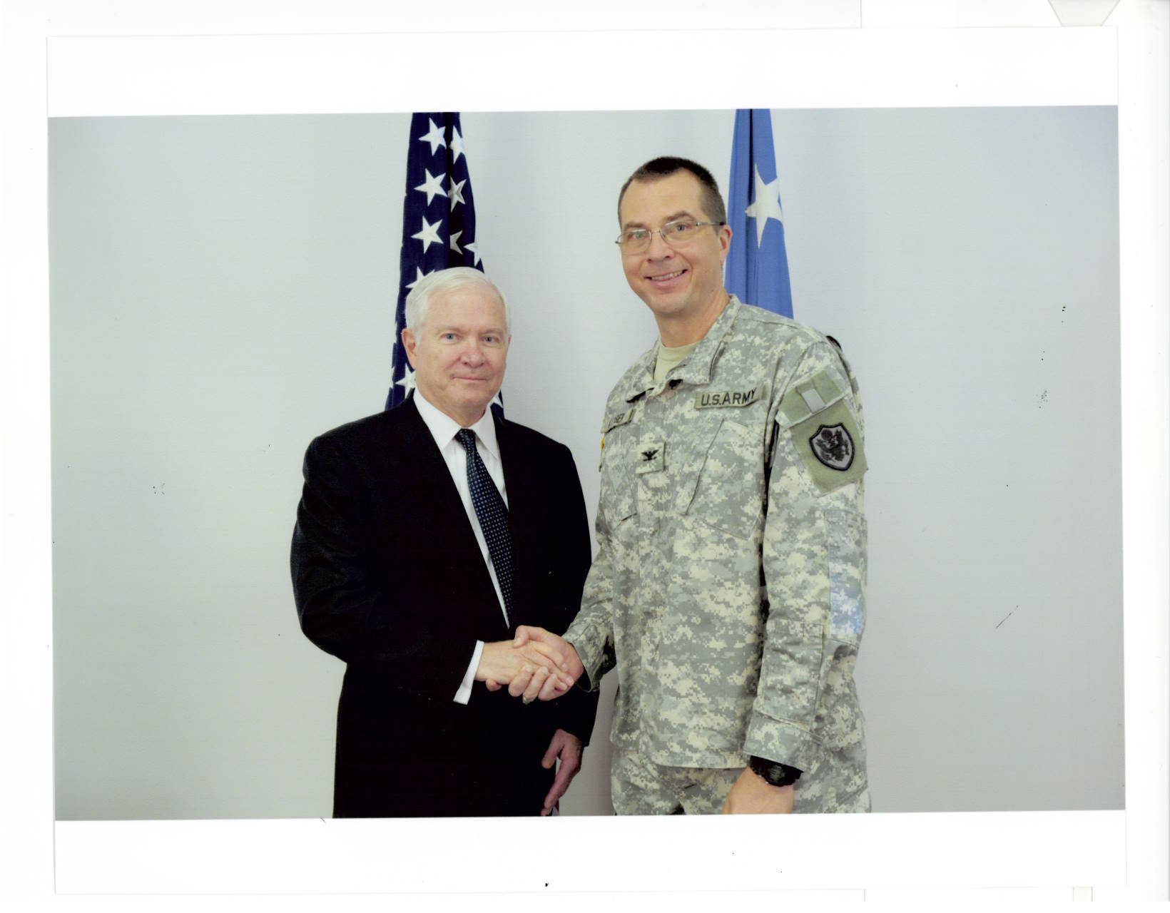 Secretary of Defense Robert Gates and Col. Gary Kayser shaking hands