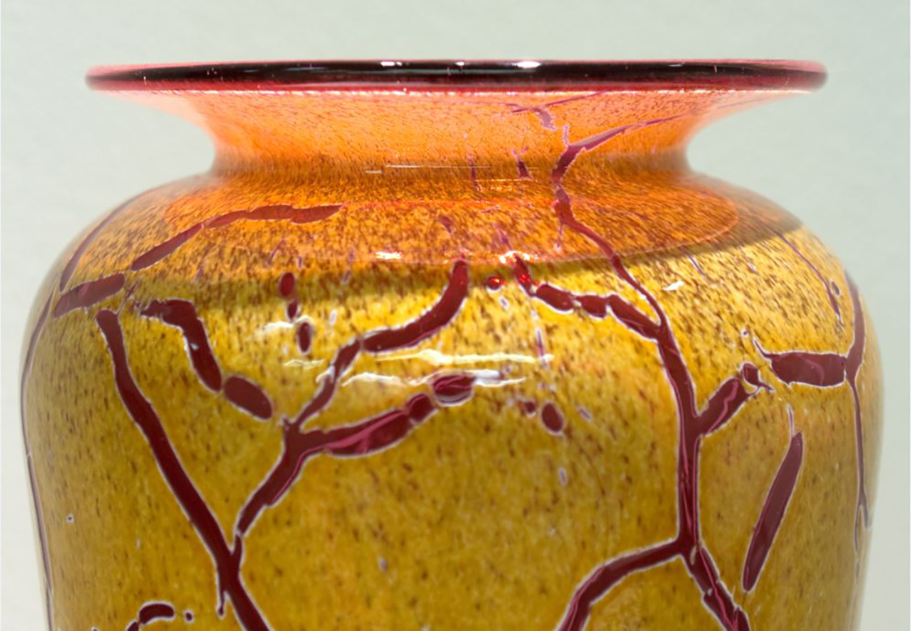 glass vase with vines of color cutting through a speckled base