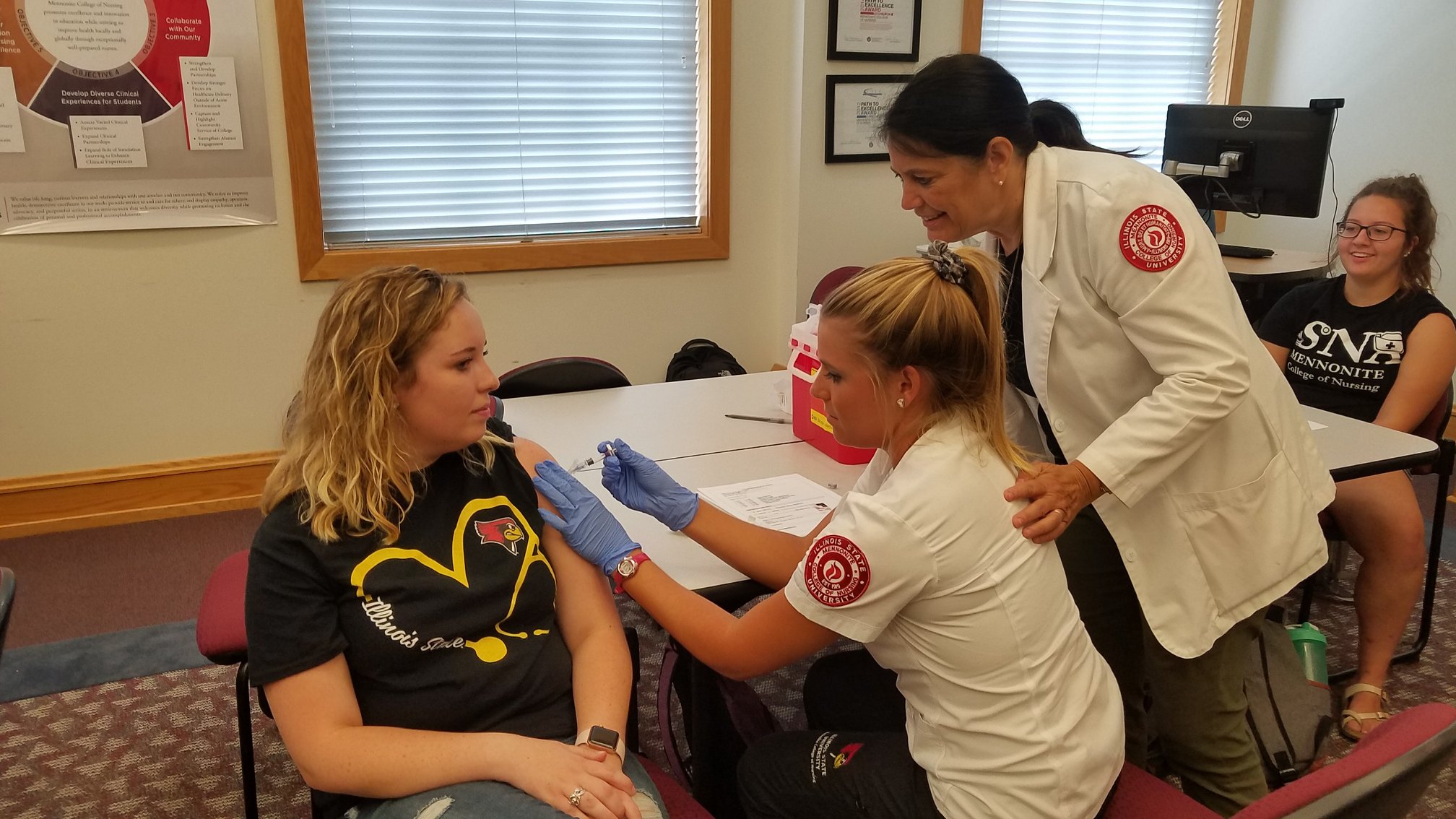 Student nurse administers flu shot.