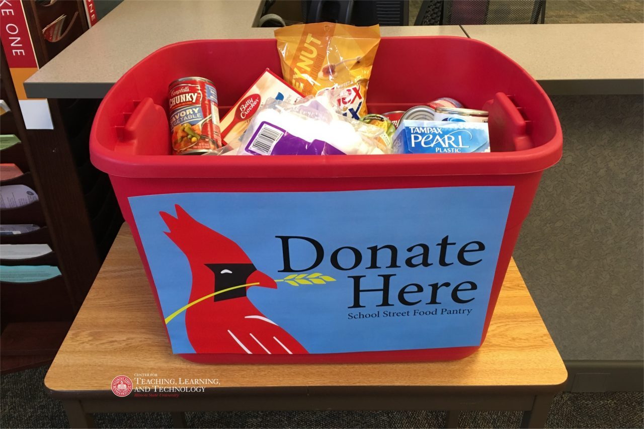Red donation tub full of items with "Donate Here - School Street Food Pantry" and logo.