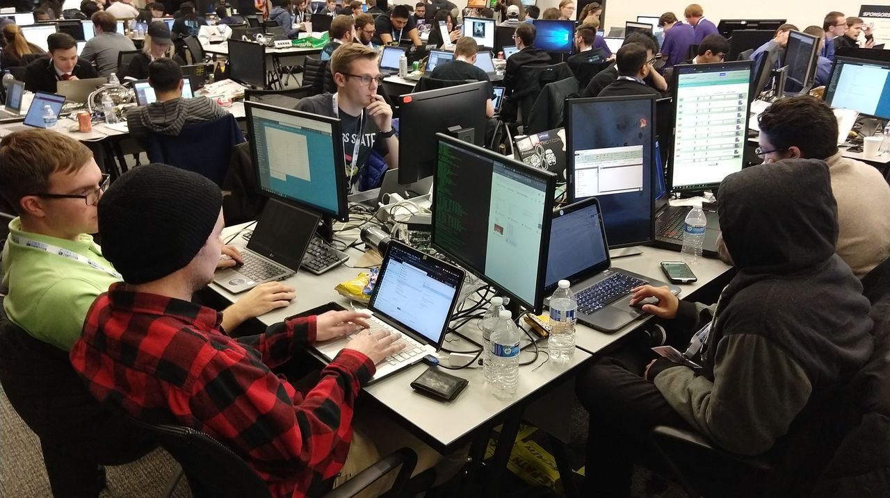 a room full of people at laptops and computers.