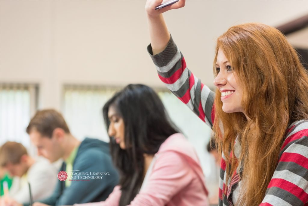 Students in class, one with hand raised