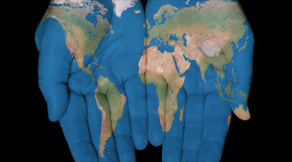 image of the map pf the world painted onto open hands