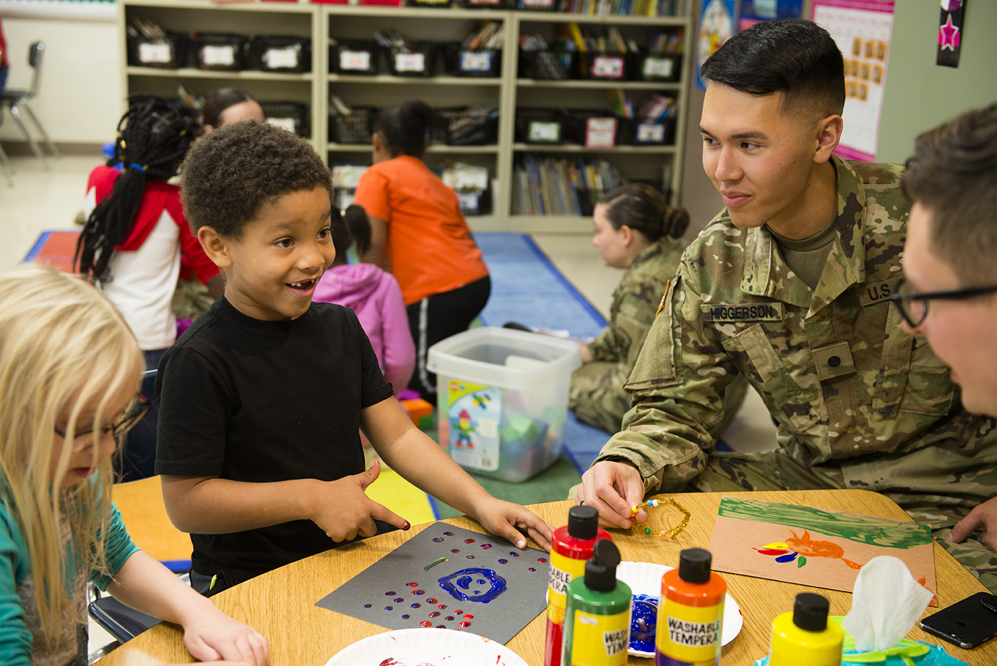 Cadet Matthew Higgerson, a sophomore, works on a finger-painting project with first graders at Fox Creek Elementary.