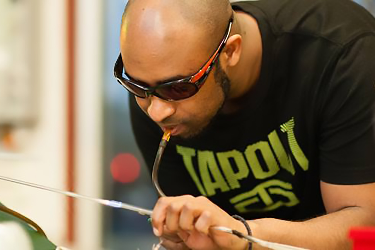 Image of Percy Echols II blowing glass.