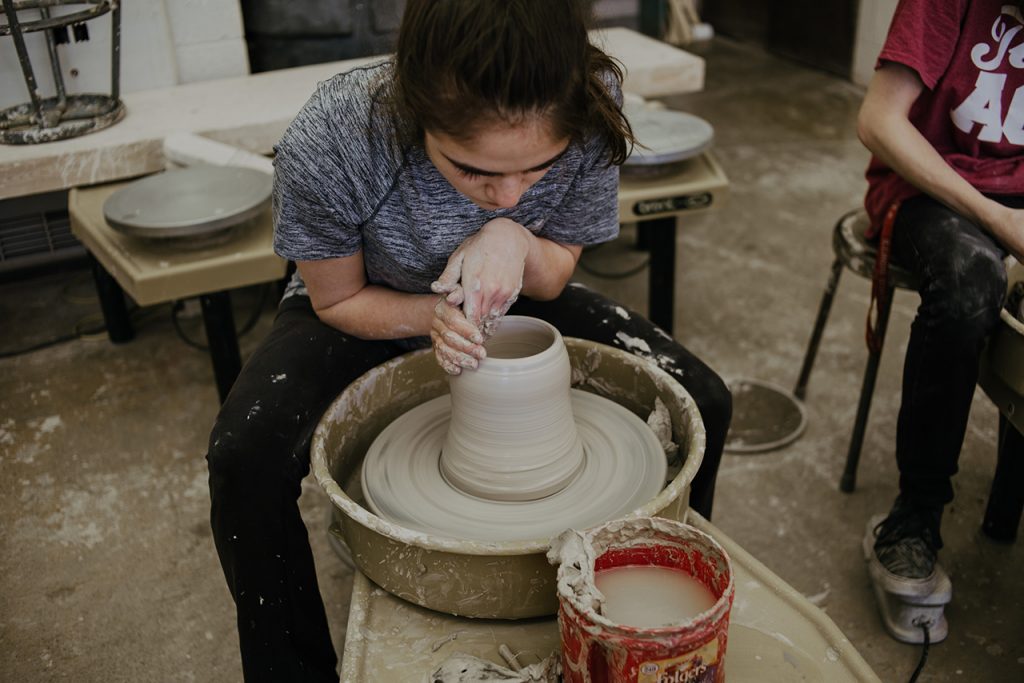 Image of a student working on a ceramic wheel.