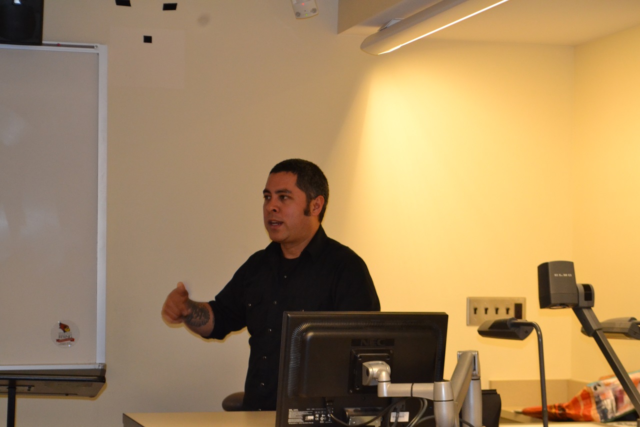 Jason De Leon giving a lecture by desk in a classroom