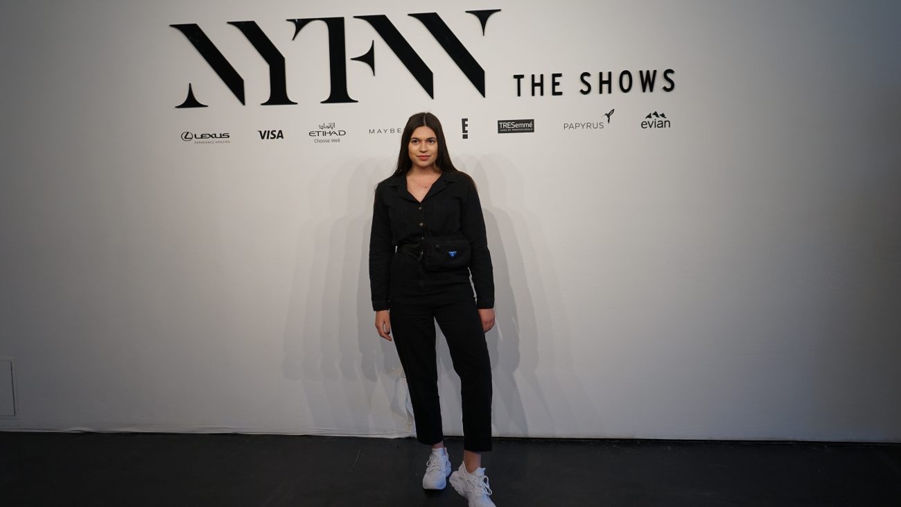 Madison Stoneman standing in front of New York Fashion Week white backdrop