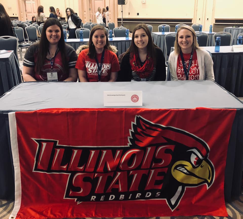 Illinois State's team at the 10th Annual College Bowl. sitting at a table with a Illinois State branded cloth.