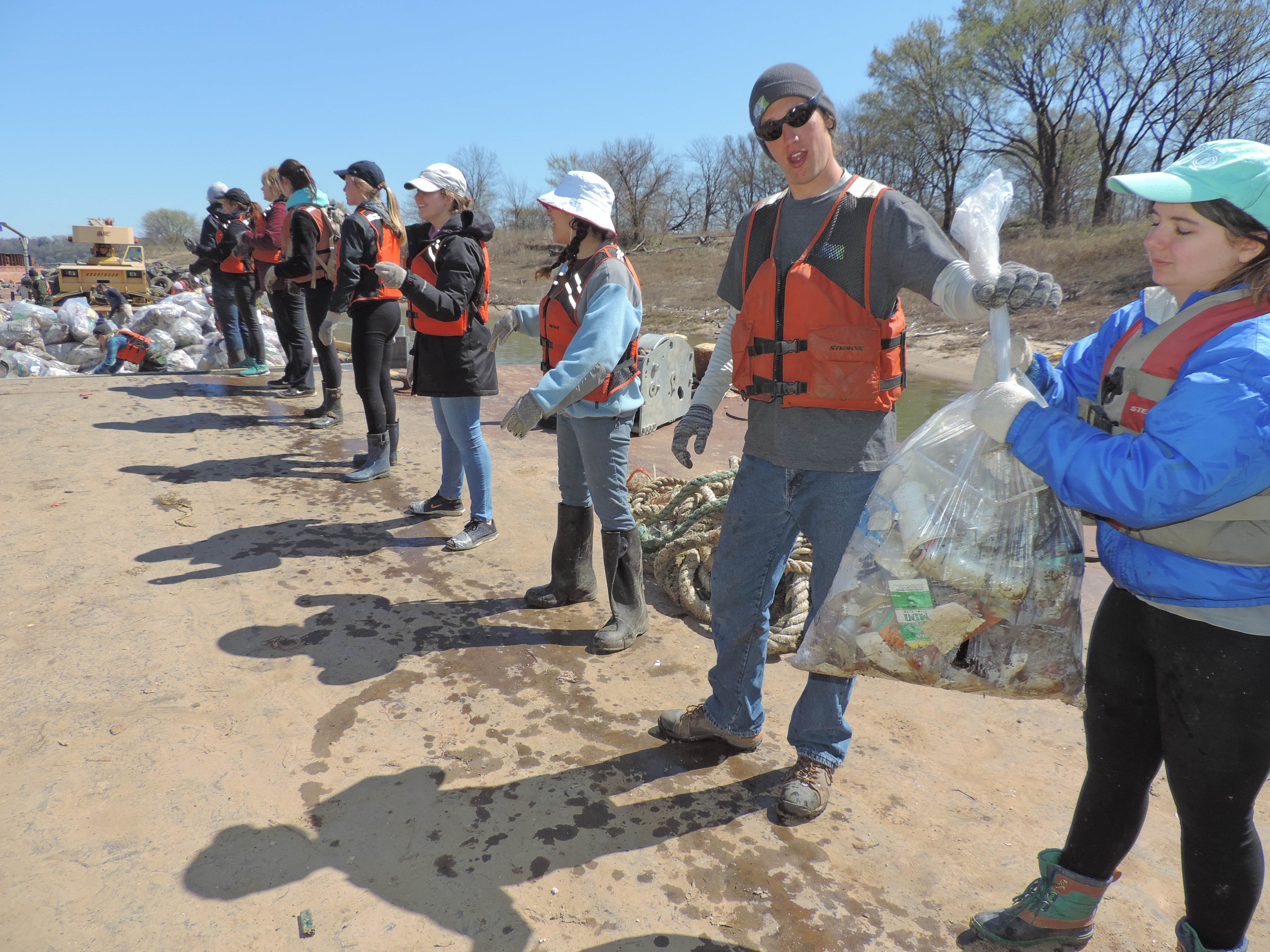 students in a line with bags of trash on Alternative Break