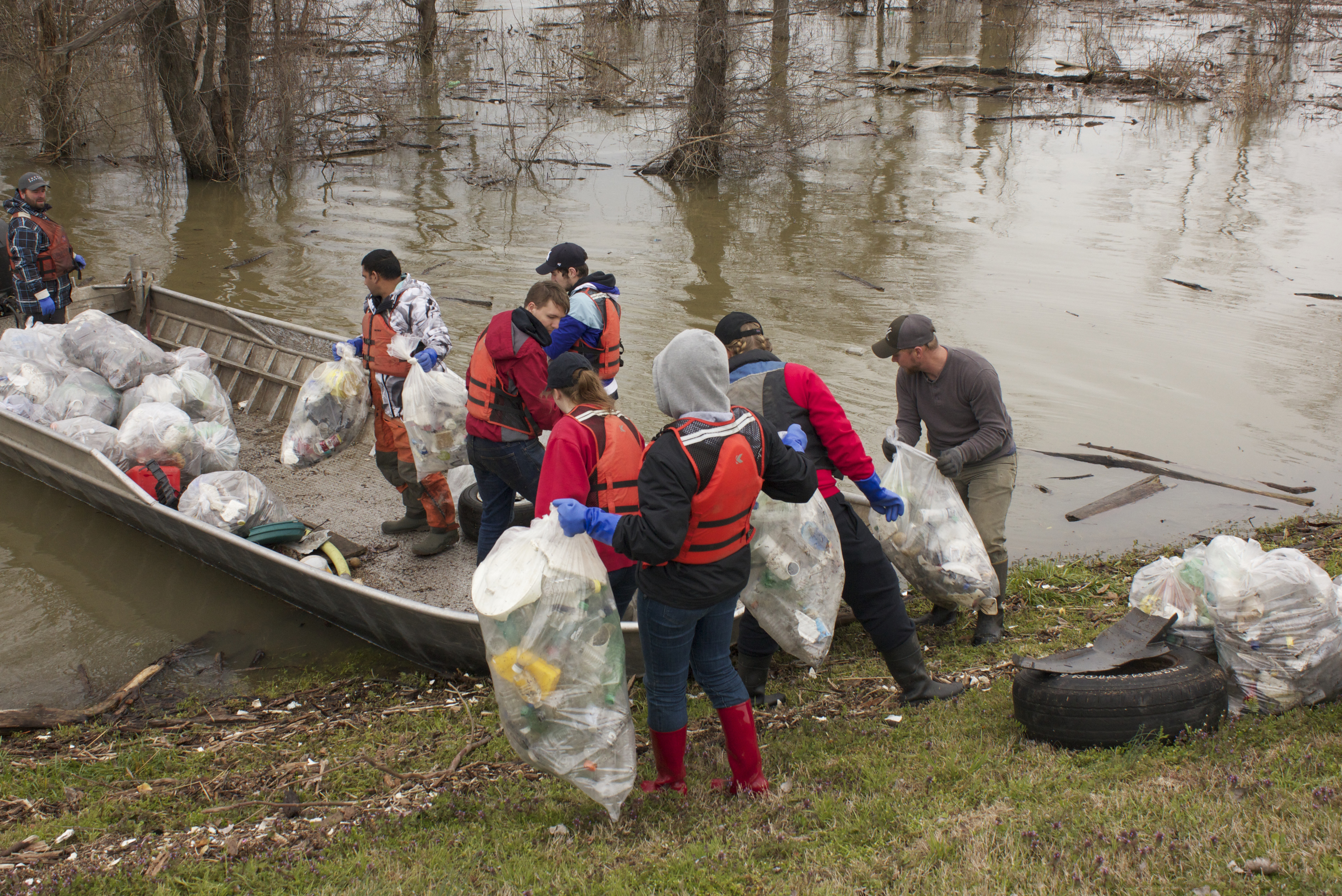 Finishing up at this site, students help load trash onto a boat that will eventually take it to the landfill.