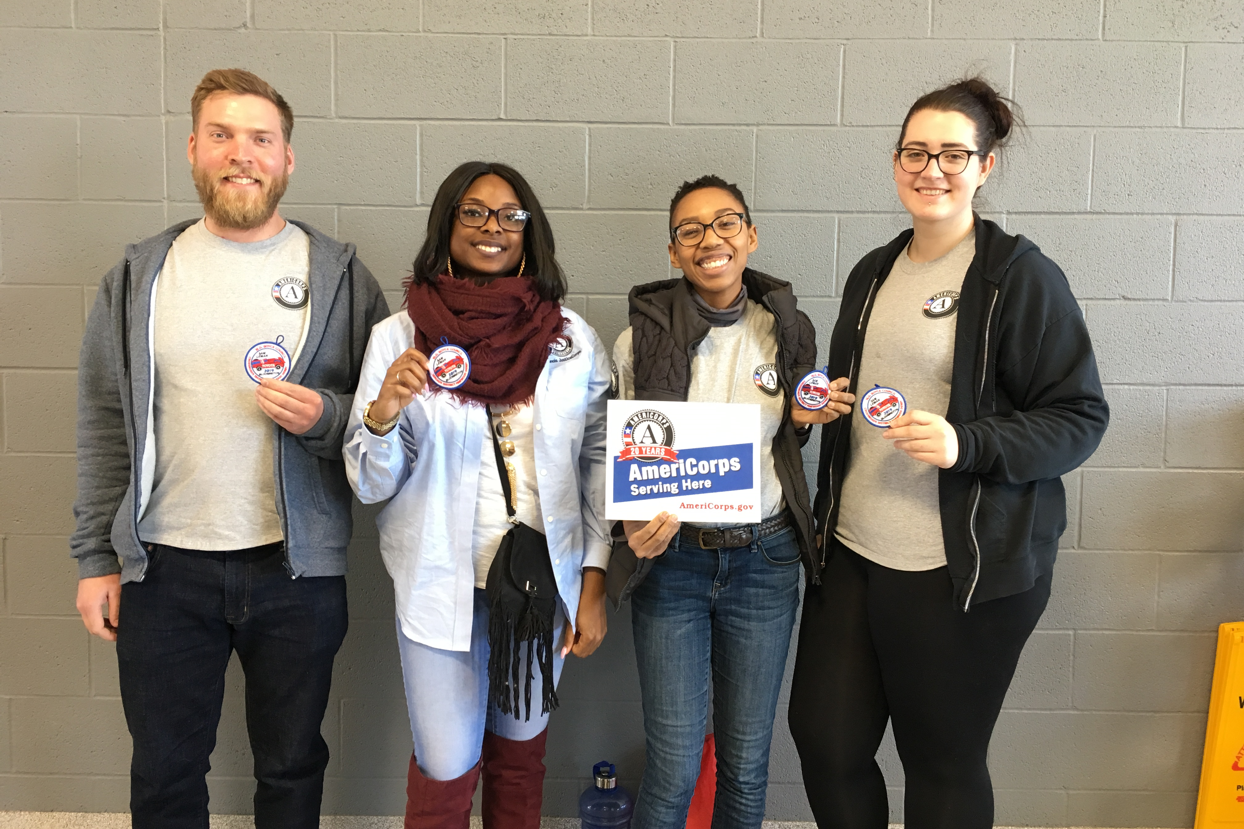 four people with AmeriCorps sign