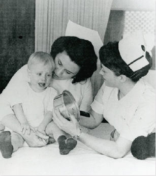 President Emerita Kathleen Hogan as a faculty member comforted a child while working with a nursing student during clinicals.