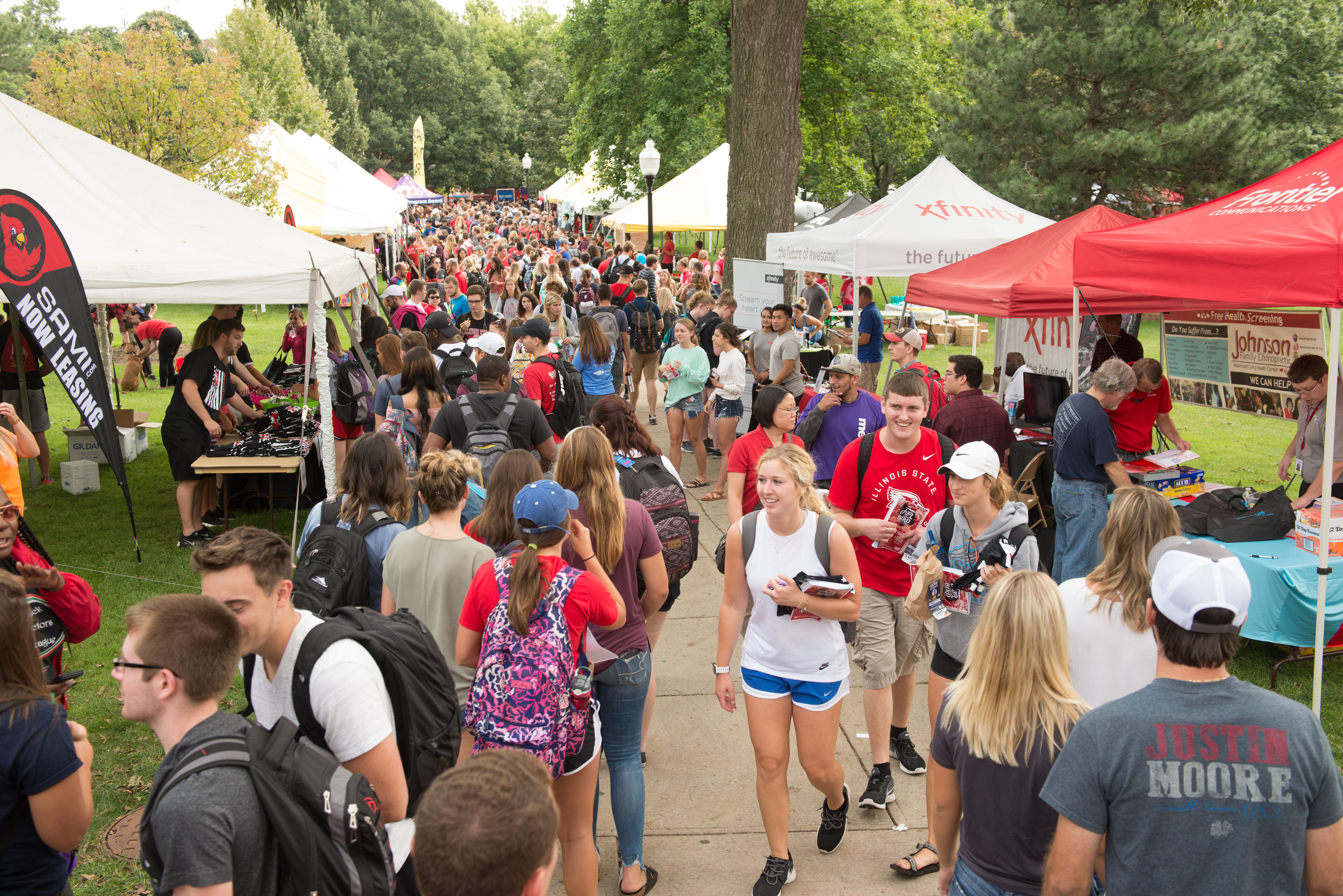 A large group of students on Illinois State's Quad between tents and tables set up for Festival ISU