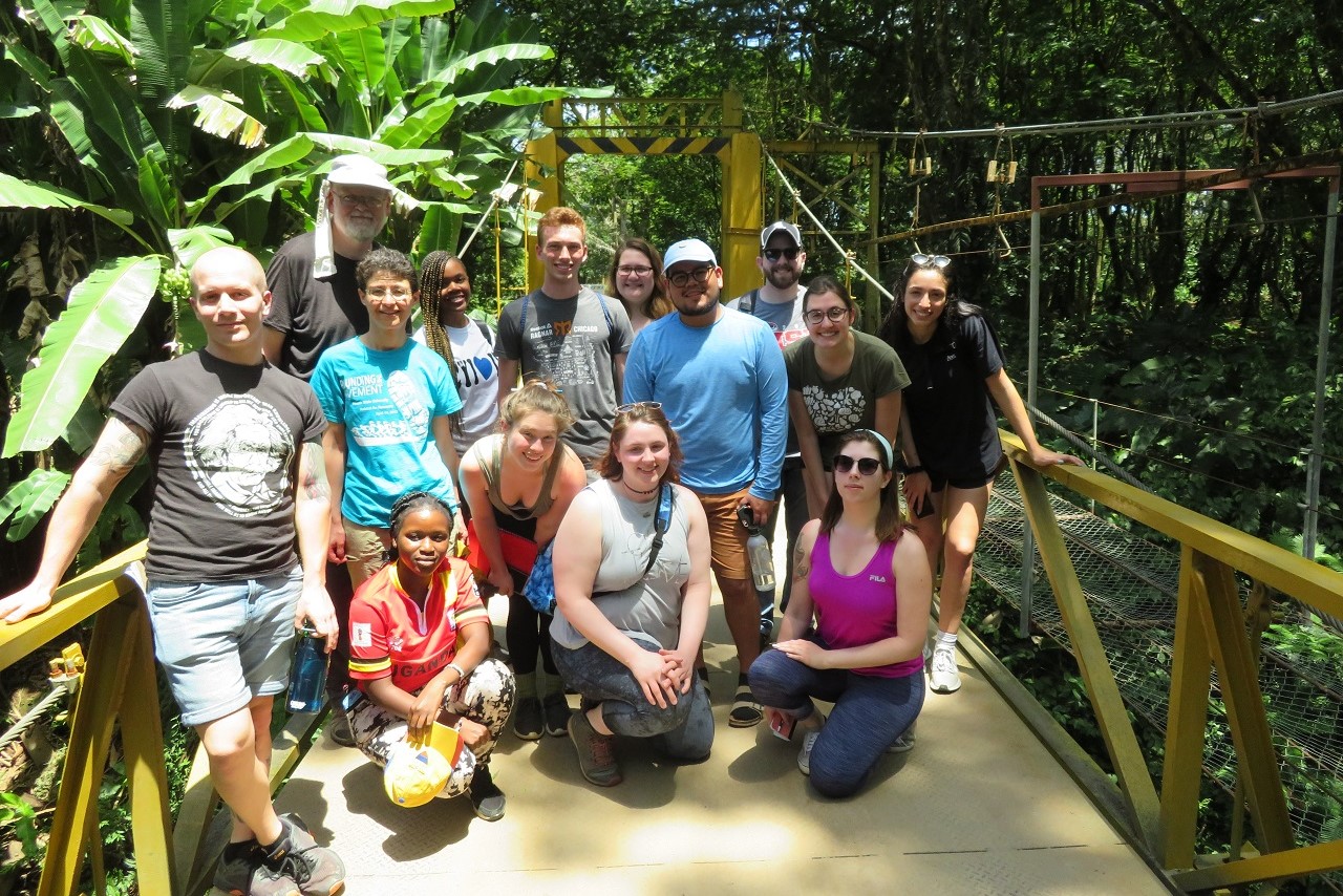 A group of people in front of a banana plantation