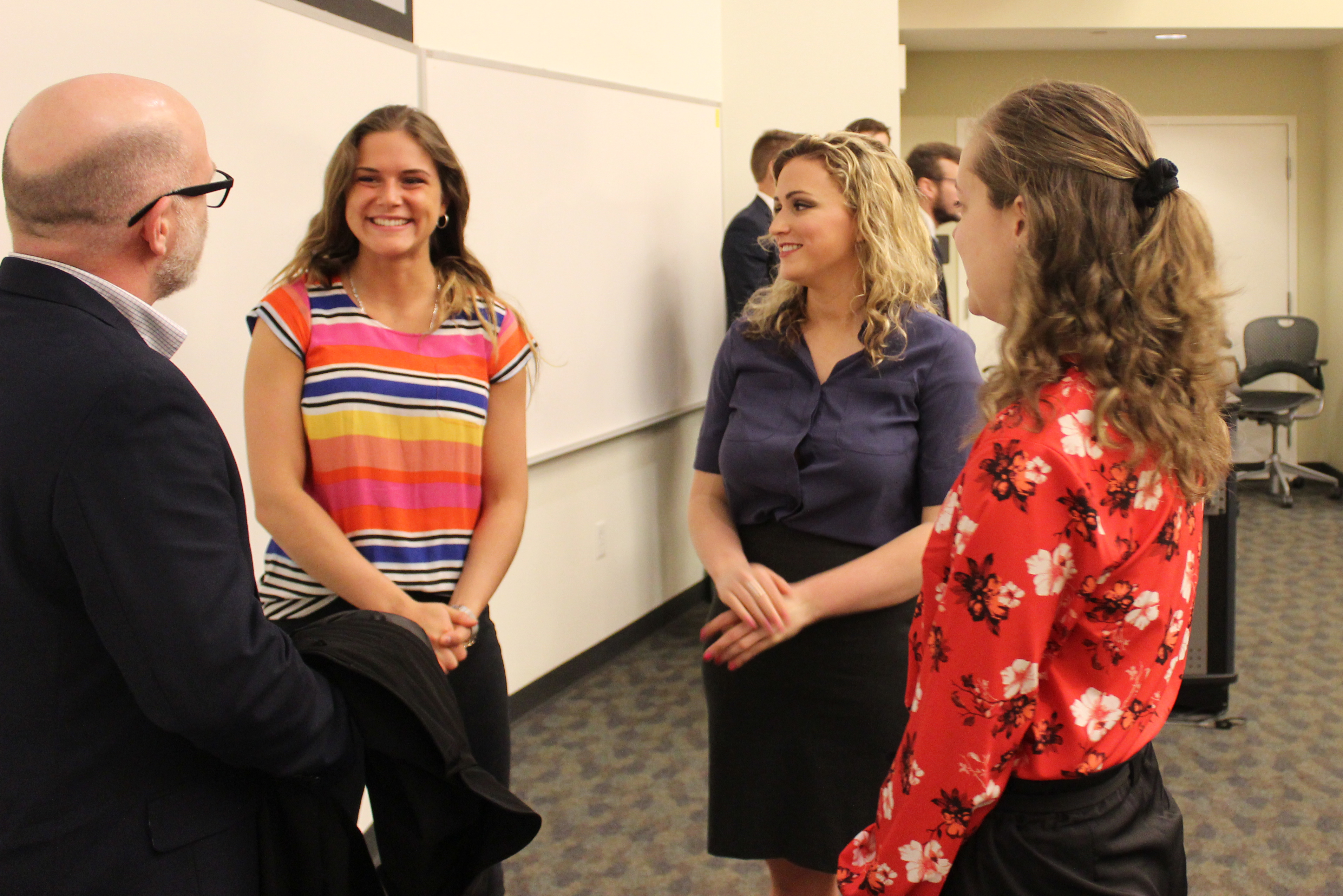 Jessica Lizzio (left), Amanda Lawler, and Brooklyn Jewsberry talk with their client after their ICC presentation. They worked with the environmentally focused nonprofit.