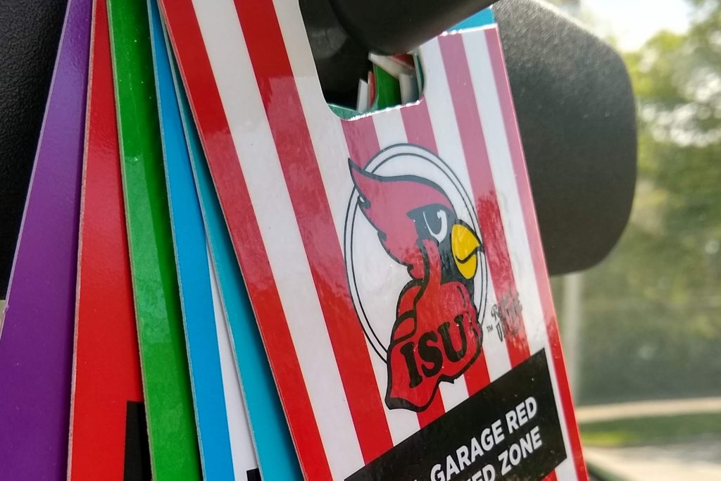 ISU Parking permits hang from the rearview mirror of a vehicle