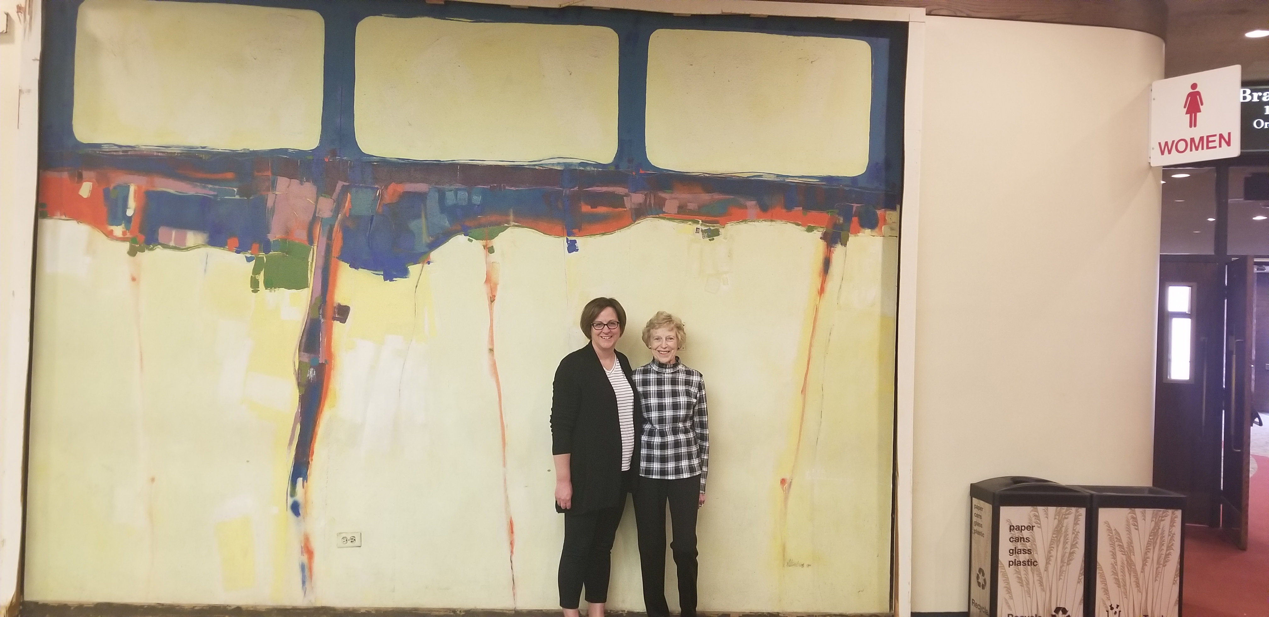 Assistant Professor Jennifer Peterson and her mother, Joan Steinburg, stand before the mural May 23. (Photograph courtesy of Bill Legett)