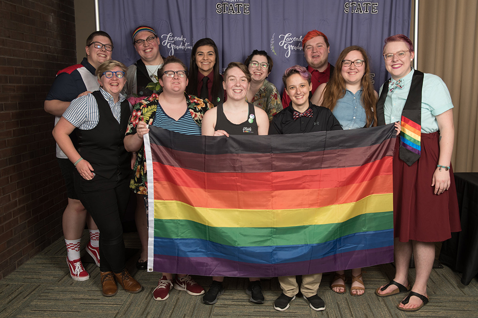 students holding rainbow flag