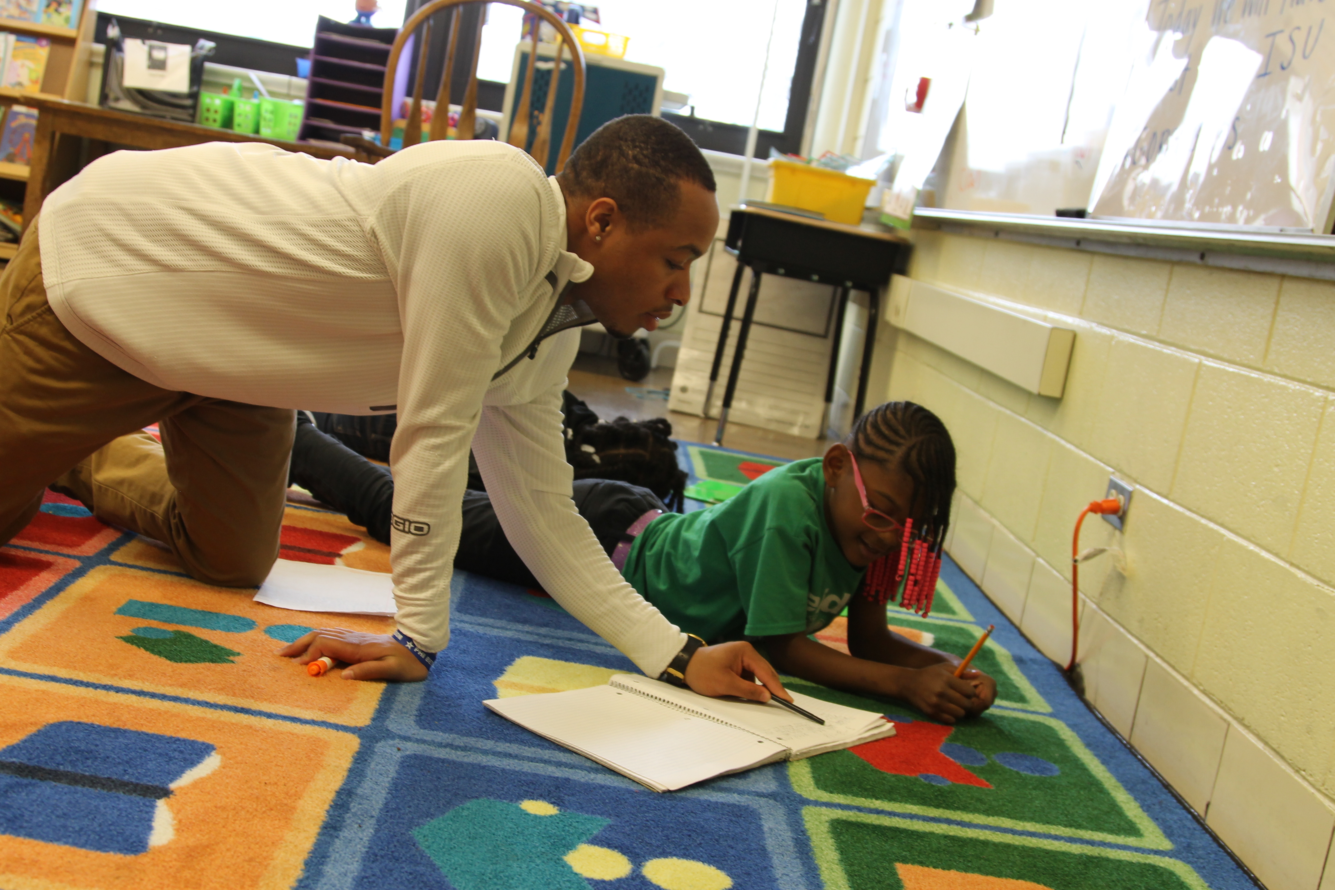 Alum Daniel Jackson works with a student on a literacy lesson.