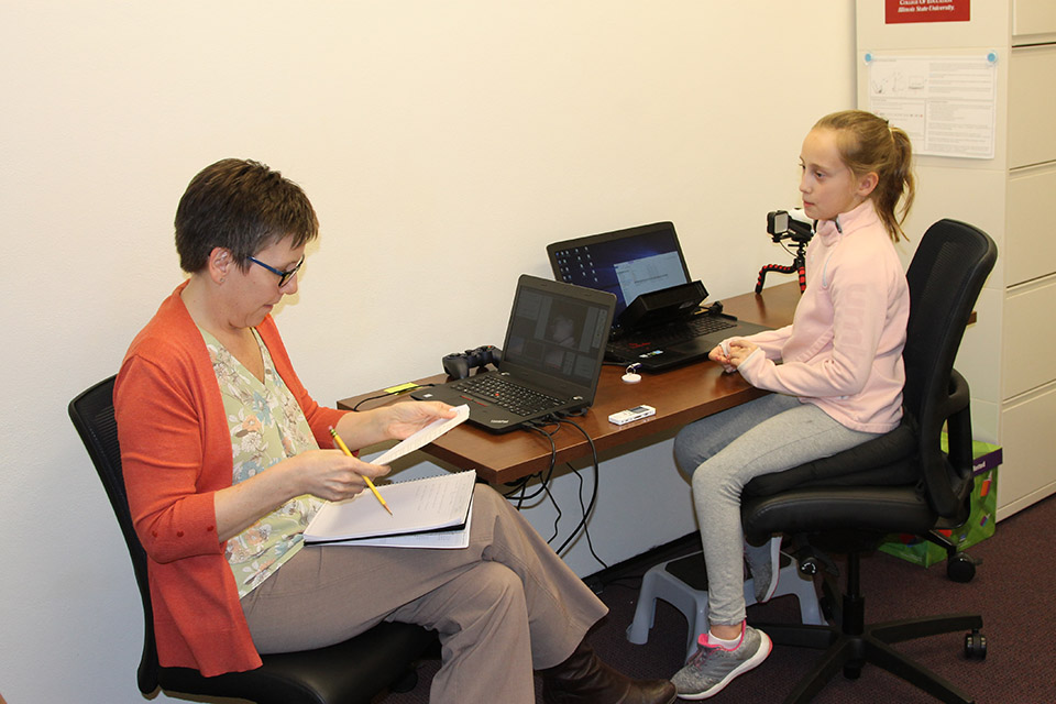 Associate Professor Deborah MacPhee works with a young learner in the EMMA lab.