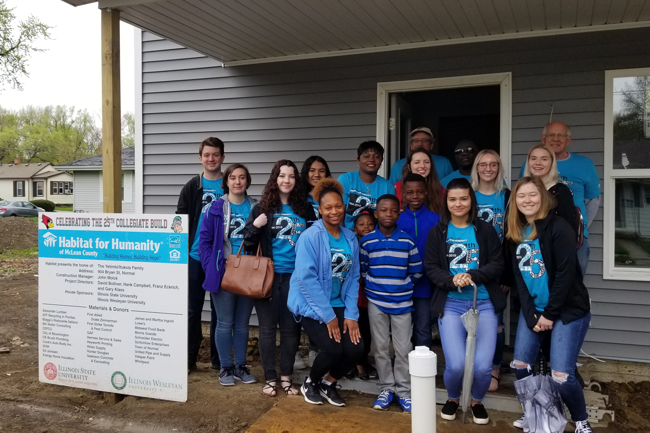 Students pose with a Habitat for Humanity family near the end of their 2018-2019 home build.