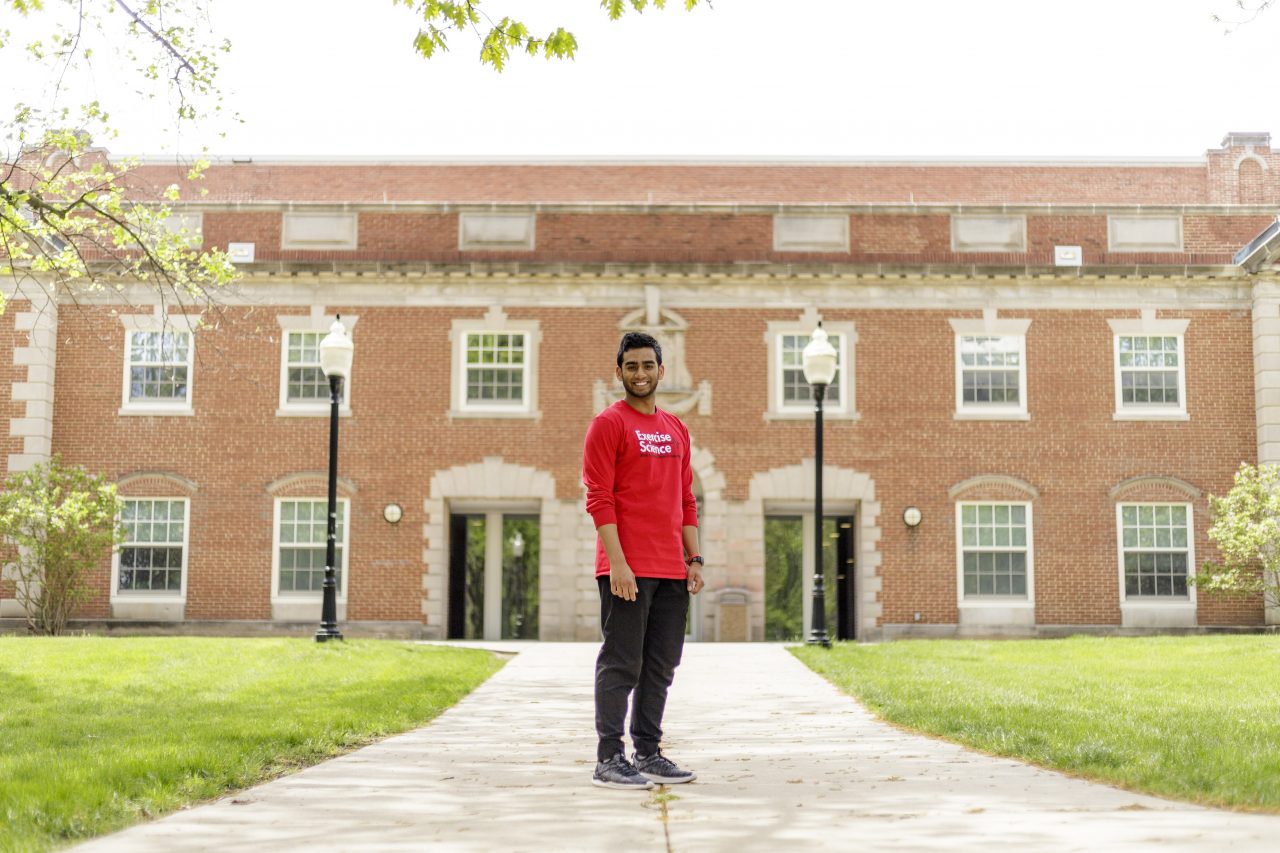 Presidential Scholar and Exercise Science major Mohammed Zaman in front of the Student Fitness Center and McCormick Hall.