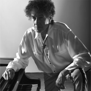 Bob Dylan leaning over a piano
