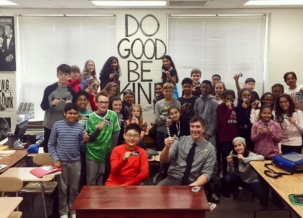 Health sciences alum Scott Todnem wins 2019 National Teacher of the Year award and his students pose with the words Do Good and Be Kind on a sign