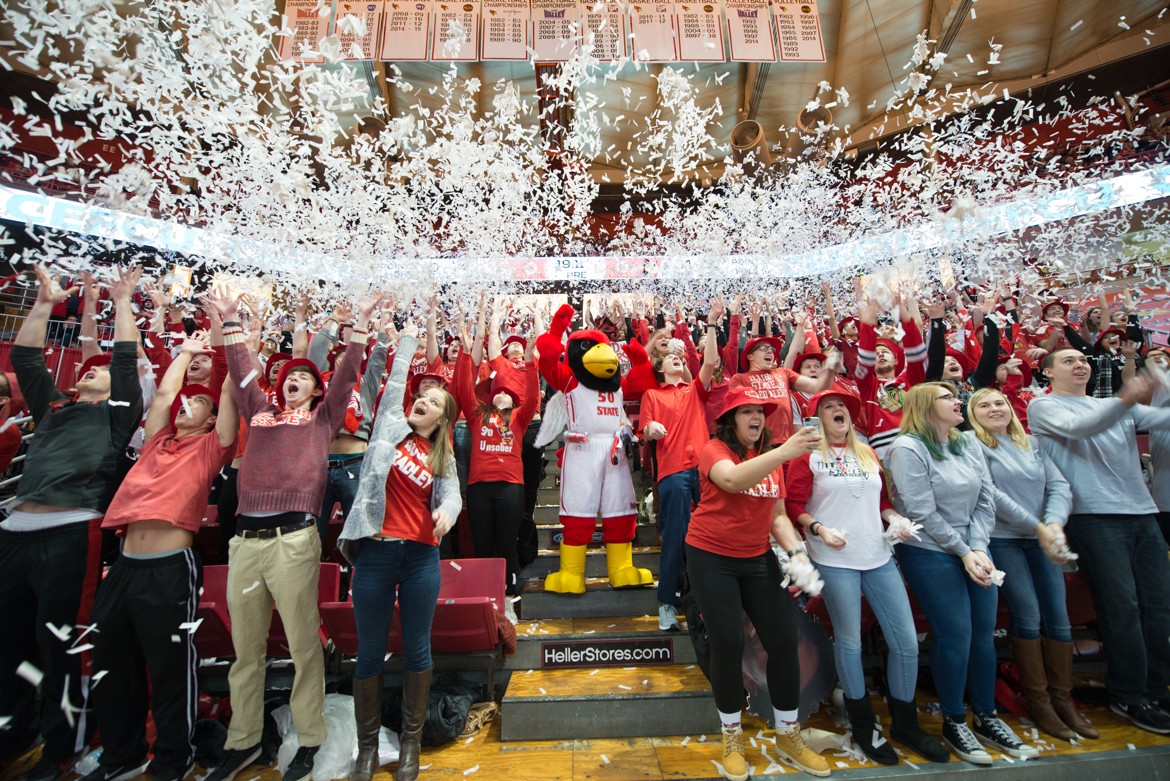 Reggie and basketball fans throw up confetti in celebration at Redbird Arena.