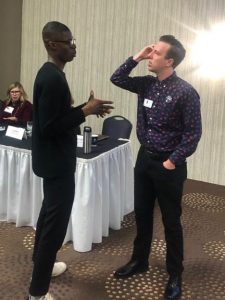 Tobi Oladejo speaks with a presenter at the HAI conference.