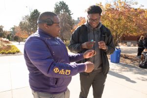 2019 Homecoming king Kendall Jordan handing bracelet to student