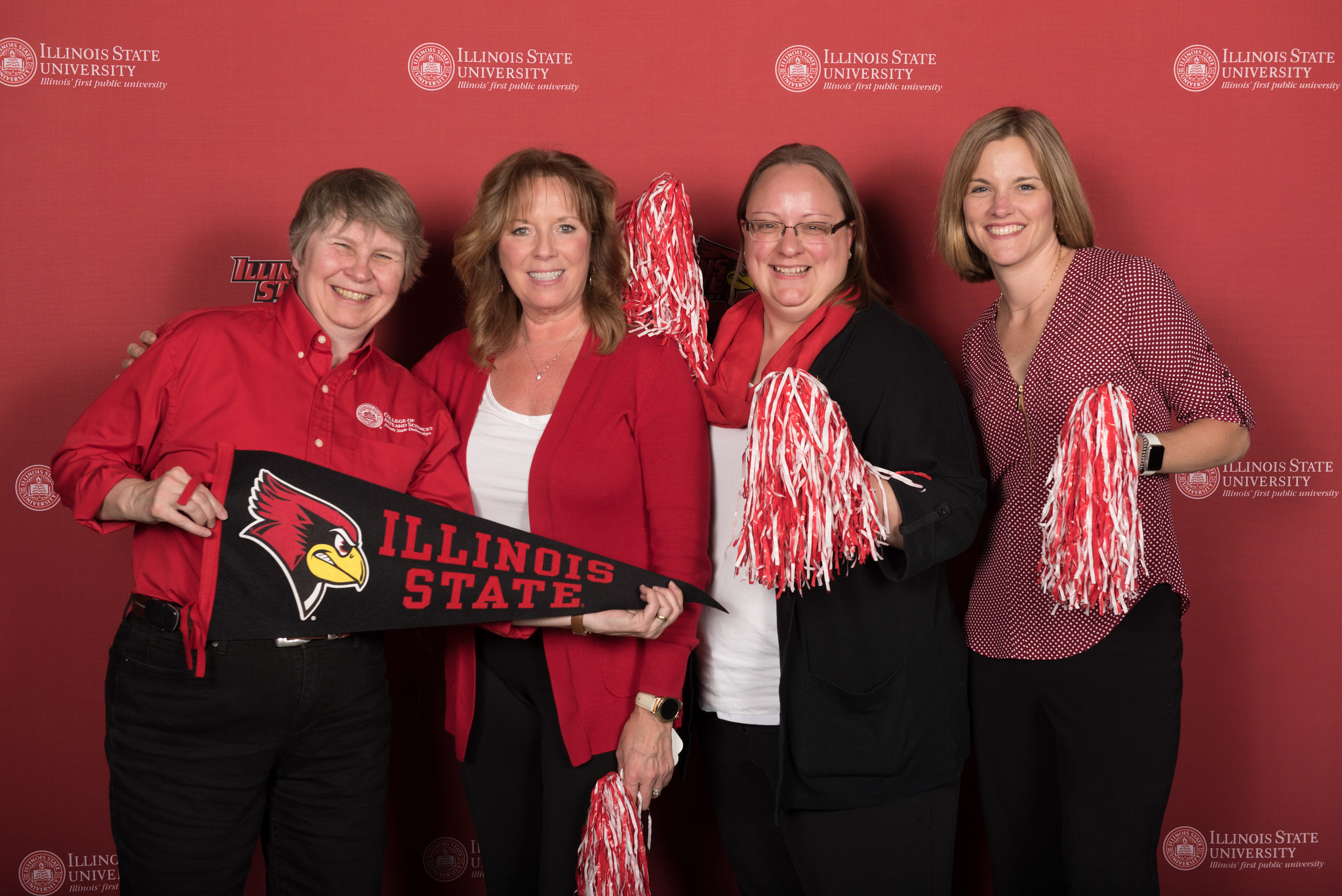 four people with ISU pom poms and a pennant