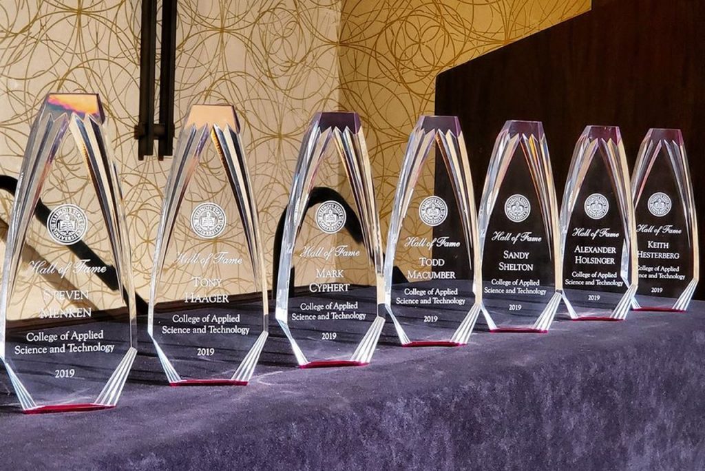 Trophies in a row on a table with a purple tablecloth