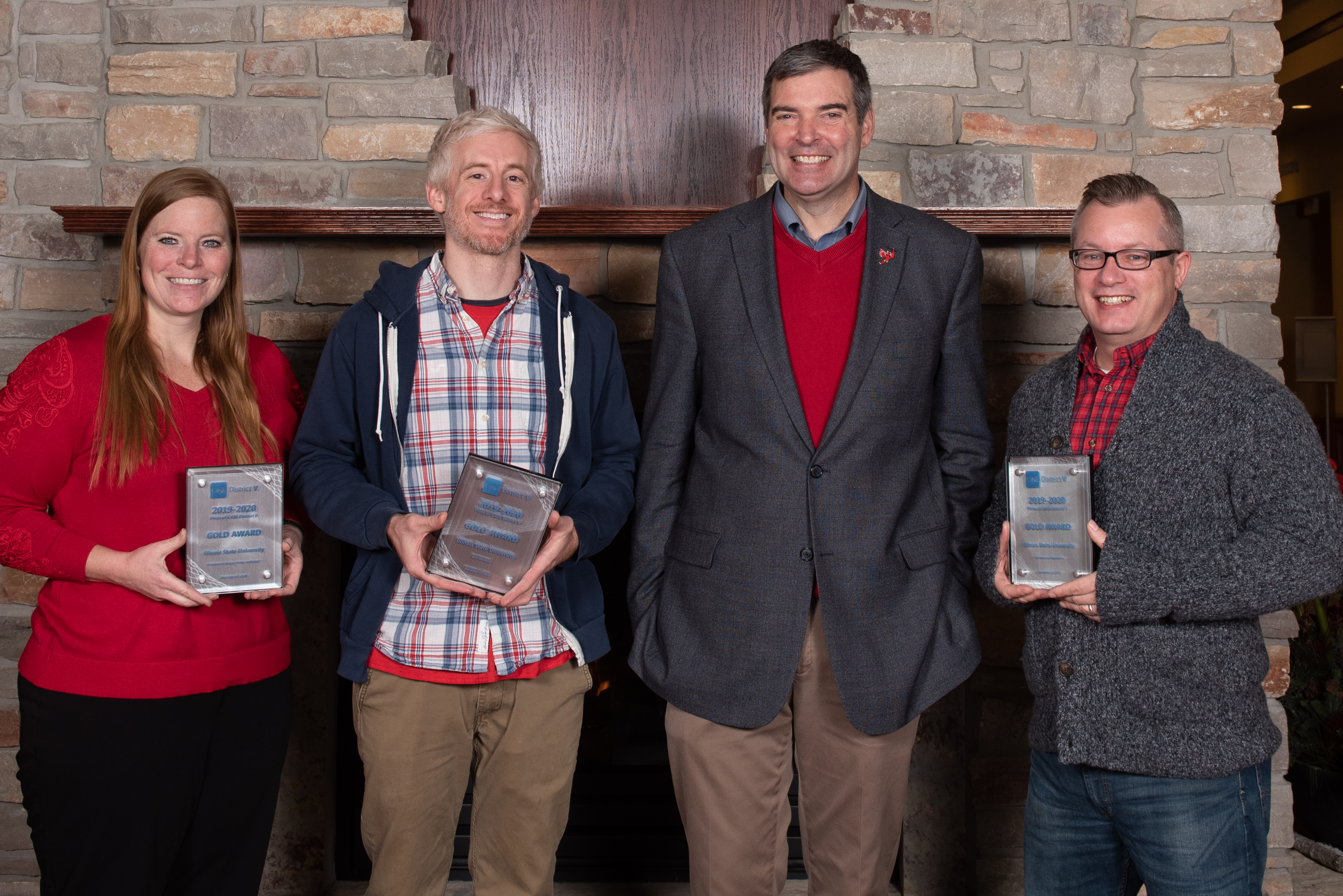 University Marketing and Communications staff display the gold awards they won in the Pride of CASE V competition: senior university photographer Lyndsie Schlink, graphic designer Evan Walles, Executive Director Brian Beam, and graphic designer Sean Thornton.