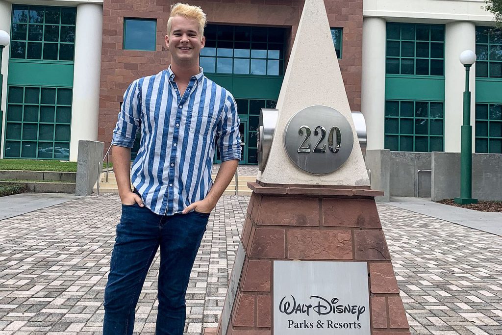 Man standing next to monument for Walt Disney