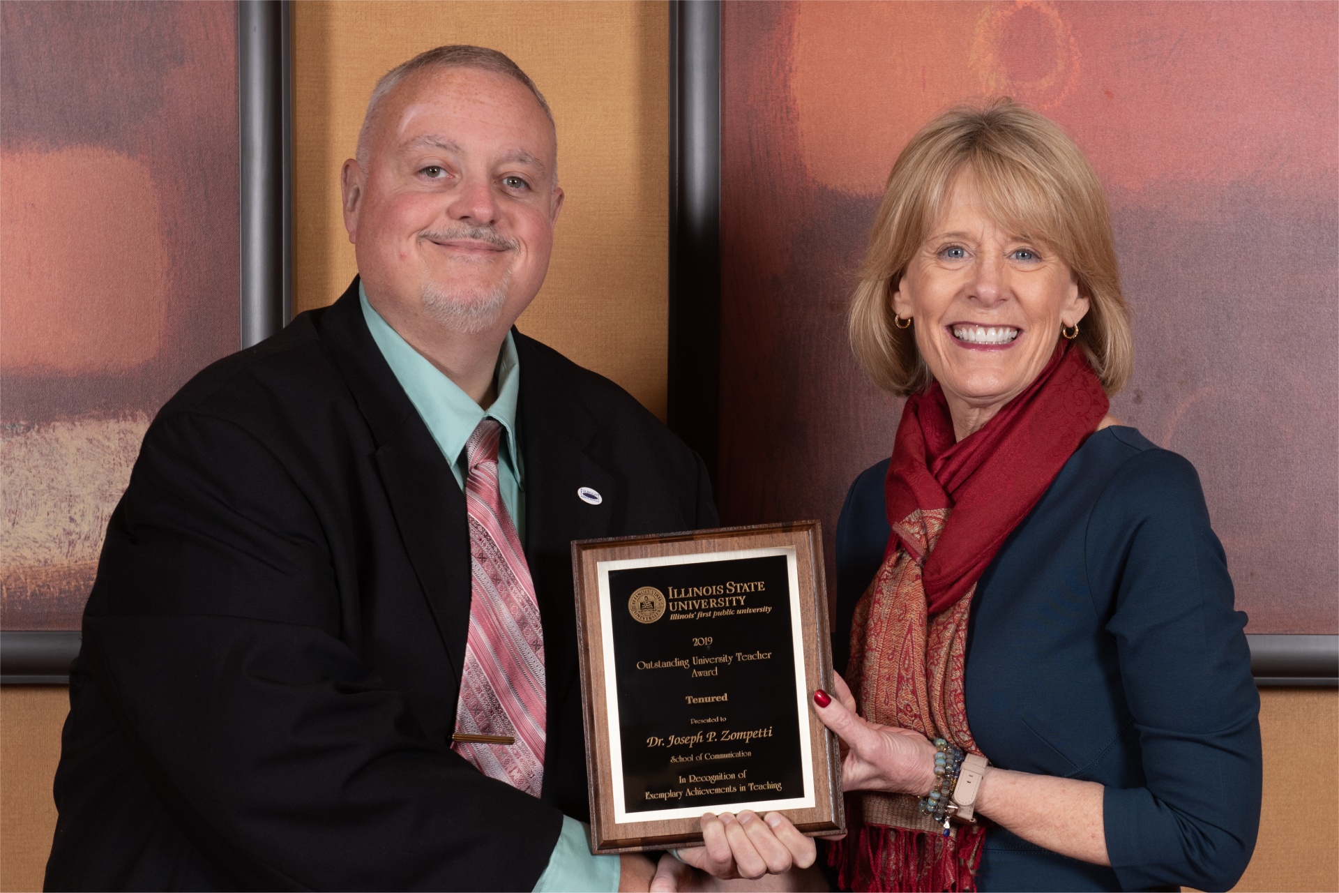 Provost Dr. Jan Murphy presents an Outstanding University Teaching Award to Dr. Joseph Zompetti, School of Communication, who was one of three faculty members so honored at the recent Teaching & Learning Symposium.