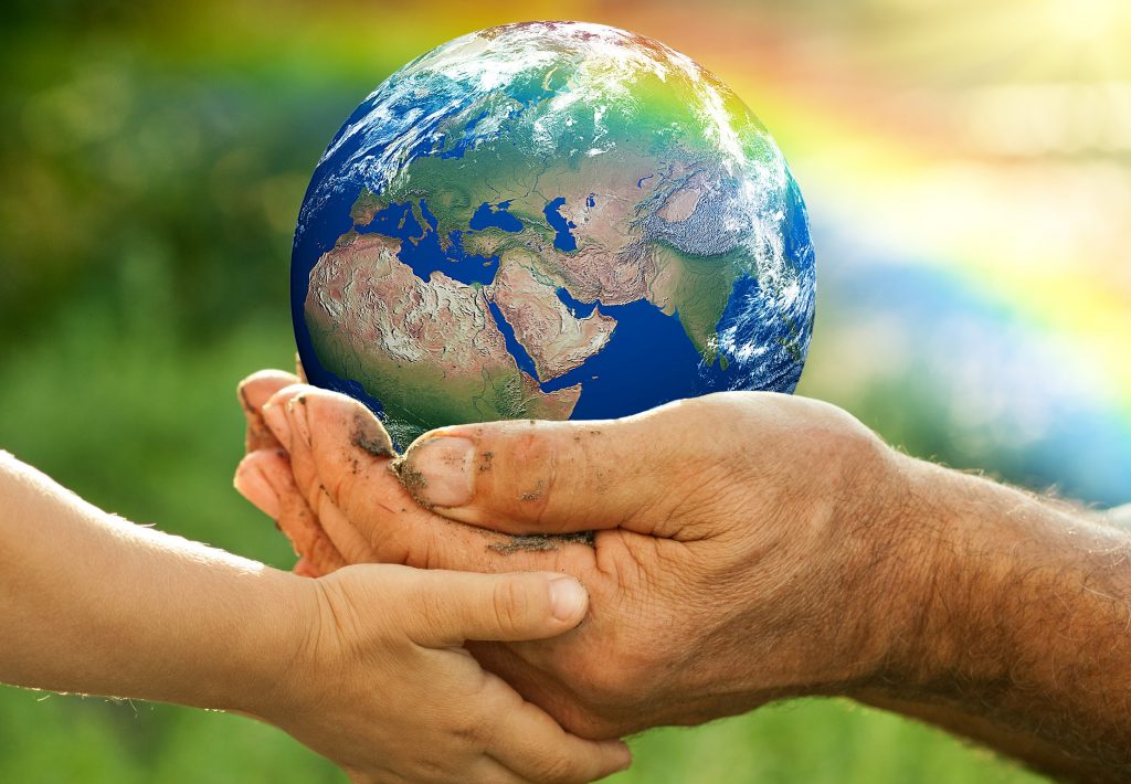 Globe held in hands of older person and child