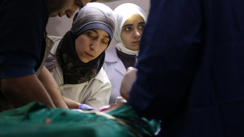 A doctor leaning over a patient