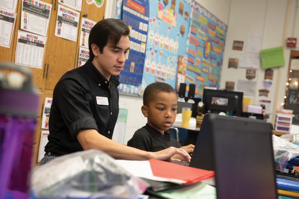 Young man tutoring a fourth grade student,