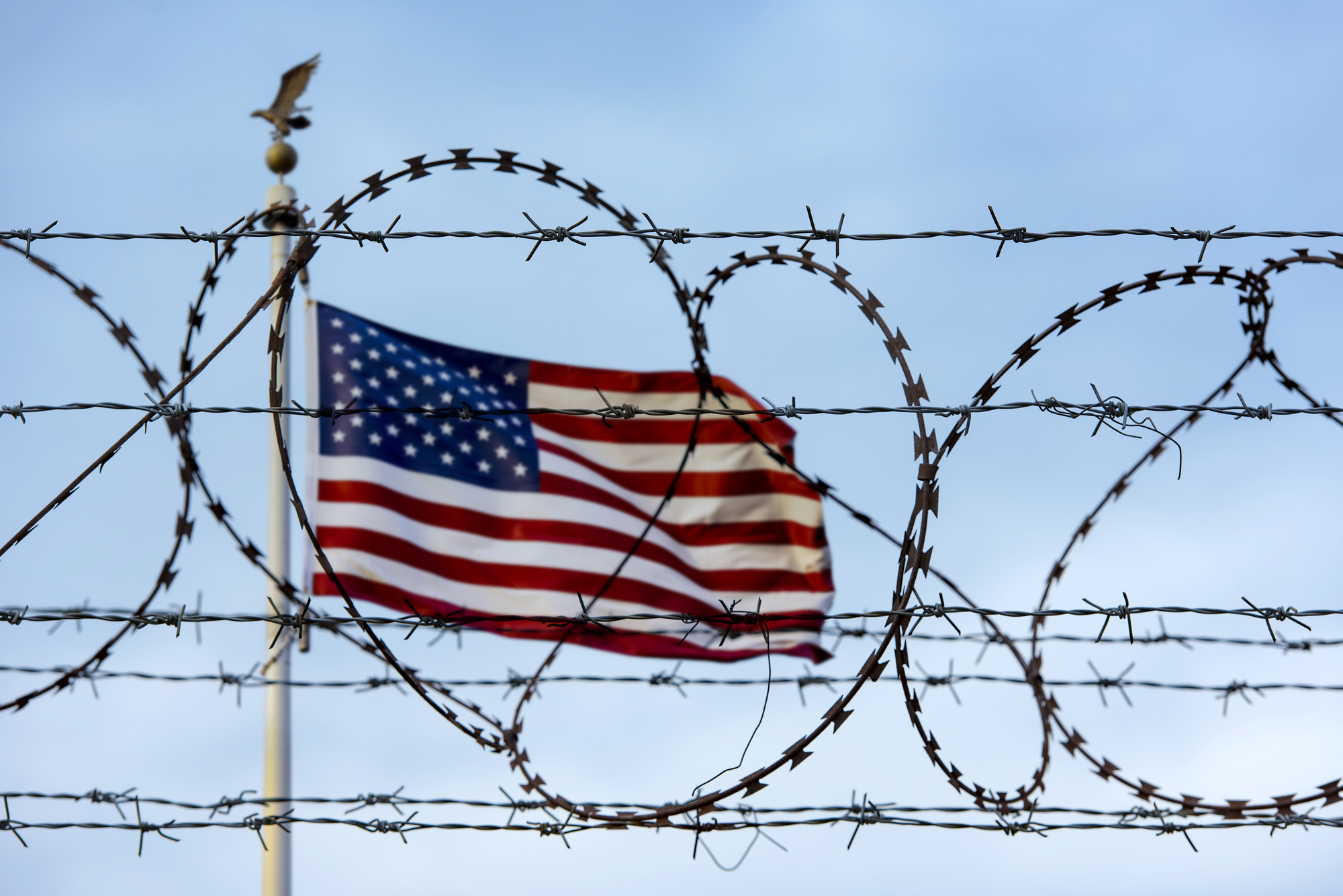 barbed wire in front of a U.S. flag