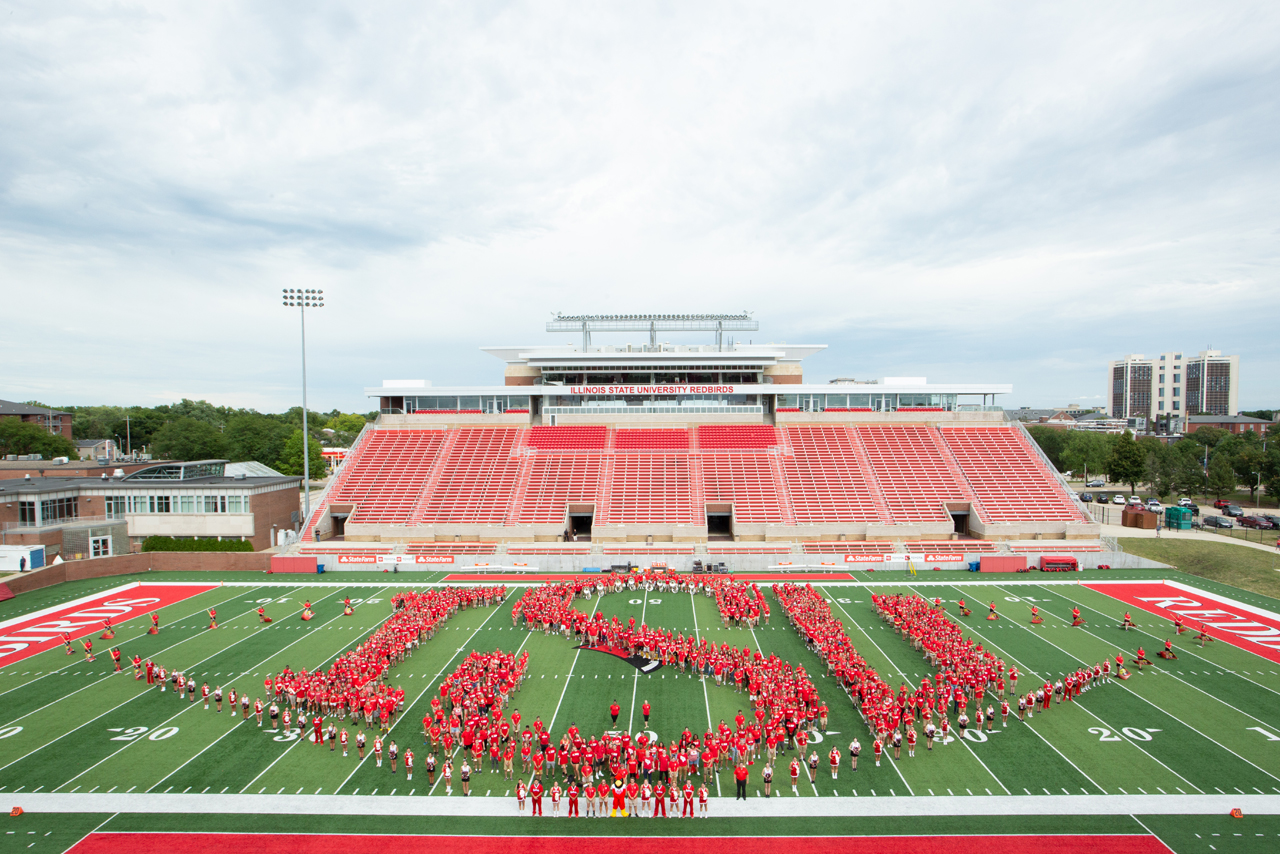 students on football field spelling out ISU
