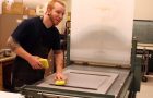 Student sponging a lithography plate